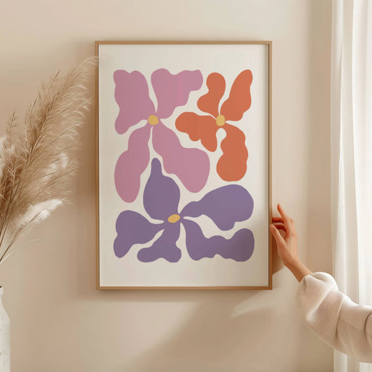 Cuadro de arte abstracto con tres flores retro en tonos lila, morado y terracota sobre fondo crema.